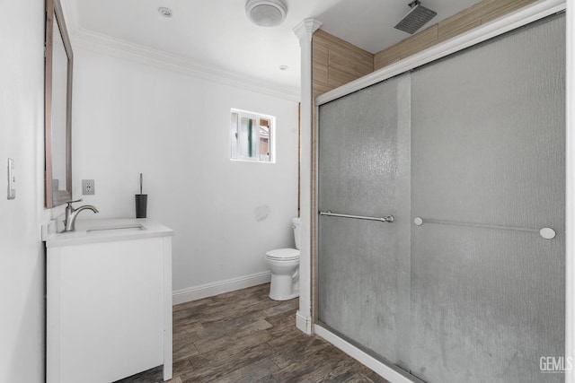 bathroom with vanity, toilet, an enclosed shower, and ornamental molding