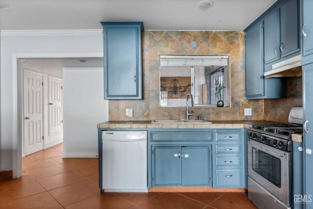 kitchen with white dishwasher, blue cabinets, stainless steel gas stove, ornamental molding, and tile counters