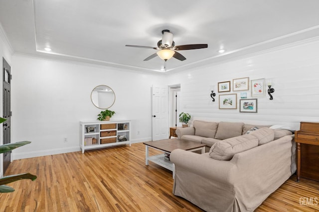 living area with light wood-style flooring, baseboards, crown molding, and ceiling fan