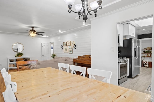 dining space with recessed lighting, light wood-type flooring, ornamental molding, and ceiling fan with notable chandelier