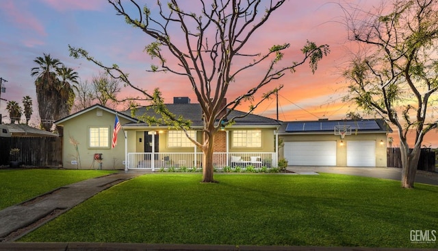 single story home featuring fence, driveway, a yard, covered porch, and roof mounted solar panels