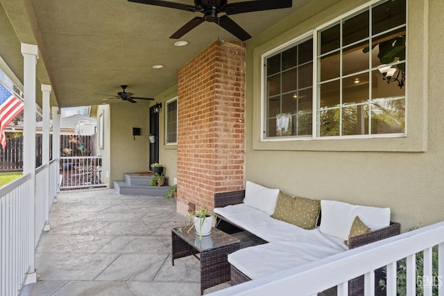 view of patio with an outdoor living space, fence, and ceiling fan