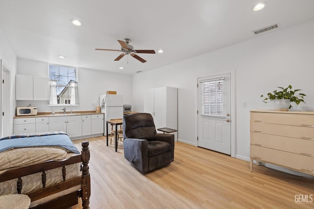 bedroom featuring recessed lighting, visible vents, freestanding refrigerator, and light wood-type flooring