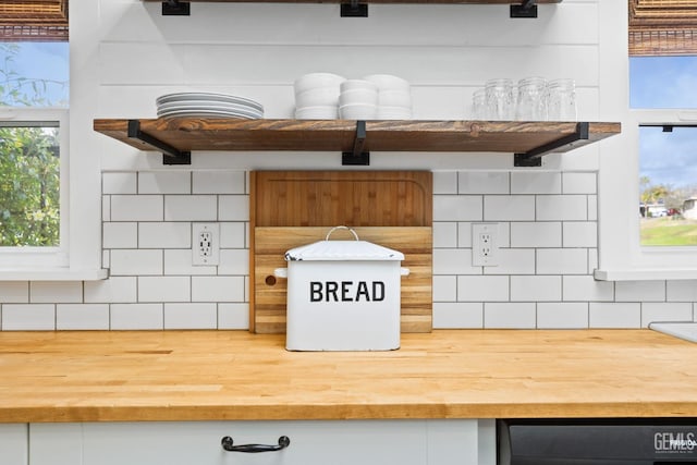 interior details with white cabinetry, tasteful backsplash, and wood counters