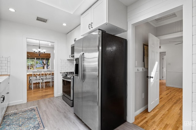 kitchen featuring light wood-type flooring, visible vents, a notable chandelier, white cabinetry, and stainless steel appliances