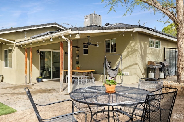 back of property with central AC, stucco siding, outdoor dining area, a ceiling fan, and a patio