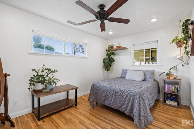 bedroom with visible vents, recessed lighting, wood finished floors, and baseboards