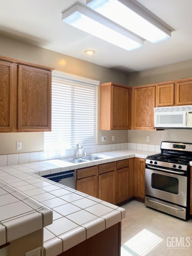 6622 Rimridge Way, Bakersfield, CA 93313 - kitchen with stainless steel appliances, tile counters, brown cabinetry, and recessed lighting