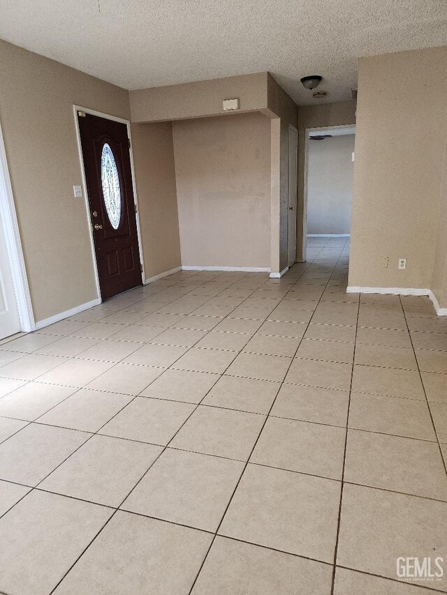 816 Rosa Ct, Delano, CA 93215 - foyer featuring a textured ceiling, baseboards, and light tile patterned floors