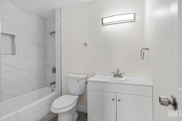 full bathroom with hardwood / wood-style floors, vanity, toilet, and tiled shower / bath