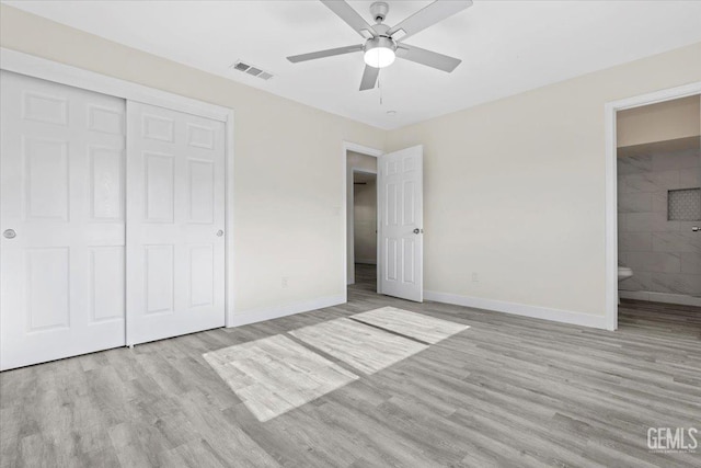 unfurnished bedroom with ceiling fan, a closet, light hardwood / wood-style floors, and ensuite bath