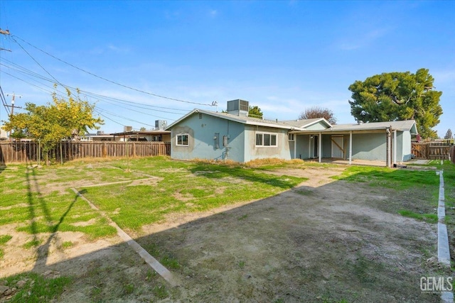 rear view of house featuring a lawn and cooling unit