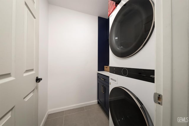 6028 Bogart Dr, Bakersfield, CA 93313 - laundry room with estacked washer and dryer, cabinet space, light tile patterned flooring, and baseboards