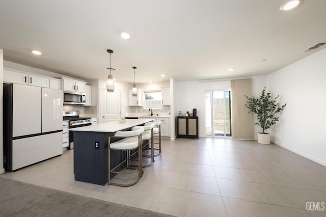 6028 Bogart Dr, Bakersfield, CA 93313 - kitchen featuring stainless steel appliances, a sink, backsplash, white cabinetry, and recessed lighting