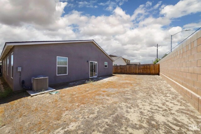 6028 Bogart Dr, Bakersfield, CA 93313 - back of house with central AC unit, a fenced backyard, and stucco siding