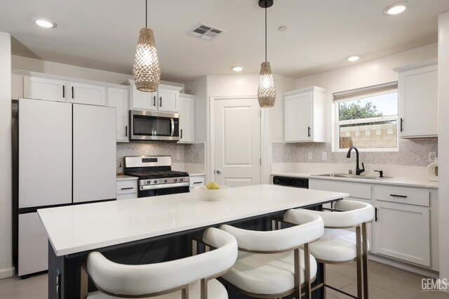 6028 Bogart Dr, Bakersfield, CA 93313 - kitchen with appliances with stainless steel finishes, a sink, a kitchen island, decorative backsplash, and white cabinets