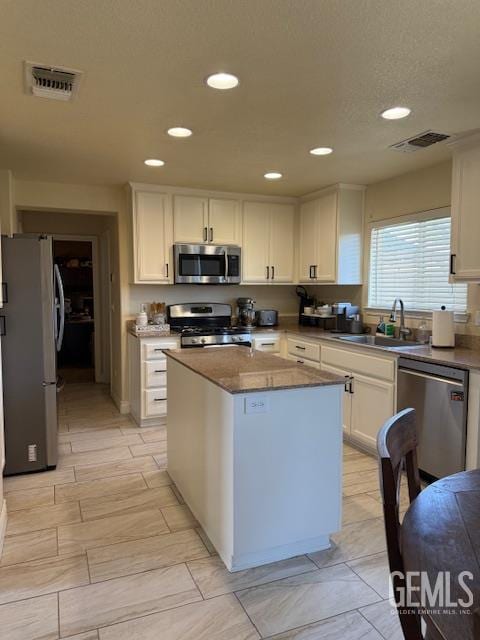 302 Quaking Aspen Ave, Wasco, CA 93280 - kitchen with stainless steel appliances, white cabinetry, recessed lighting, and a kitchen island