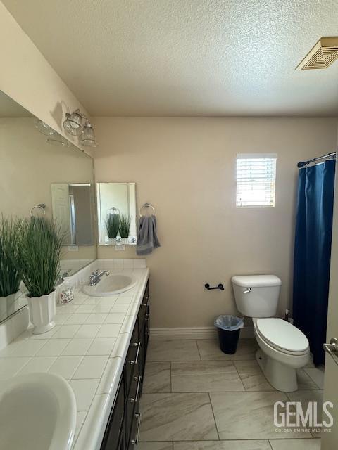 302 Quaking Aspen Ave, Wasco, CA 93280 - full bathroom featuring double vanity and a textured ceiling