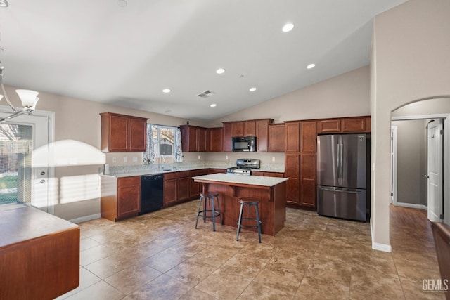 kitchen featuring black appliances, vaulted ceiling, a notable chandelier, a kitchen island, and a kitchen bar