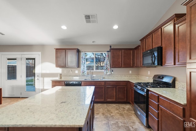 kitchen with black appliances, a kitchen island, light stone counters, and sink