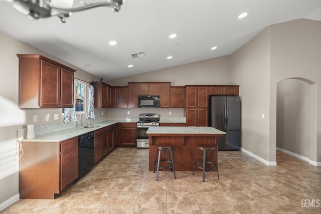 kitchen featuring a center island, sink, a kitchen breakfast bar, lofted ceiling, and black appliances