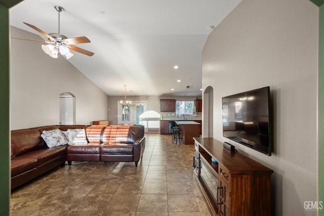 living room with tile patterned floors, high vaulted ceiling, and ceiling fan with notable chandelier