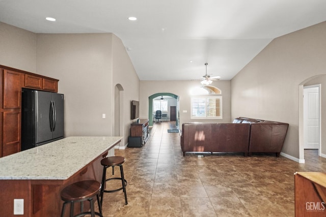 living room with ceiling fan and high vaulted ceiling