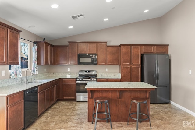 kitchen with light stone countertops, vaulted ceiling, sink, black appliances, and a center island