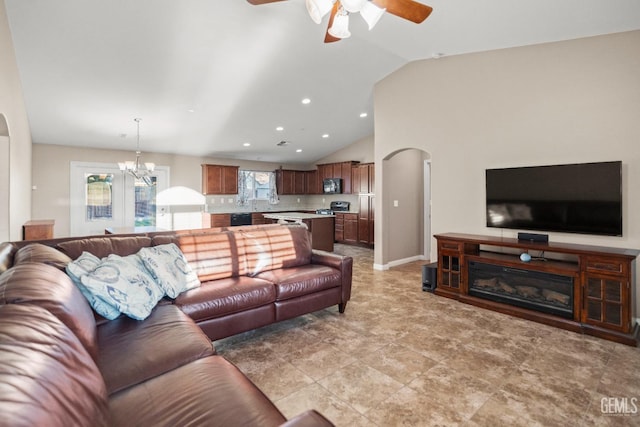 living room featuring lofted ceiling and ceiling fan with notable chandelier