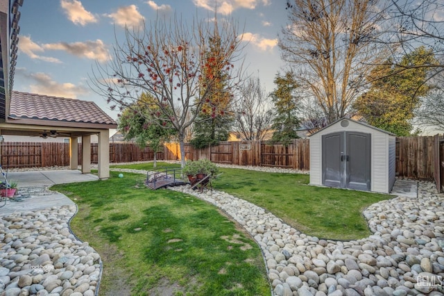 yard at dusk featuring a patio and a shed