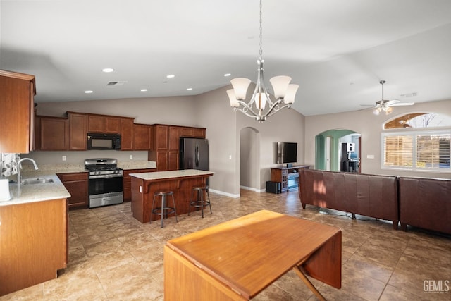 kitchen featuring ceiling fan with notable chandelier, sink, decorative light fixtures, a kitchen island, and stainless steel appliances