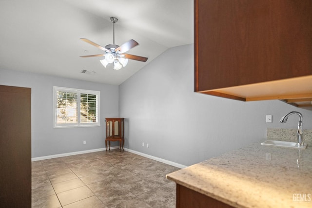 interior space featuring ceiling fan, lofted ceiling, and sink