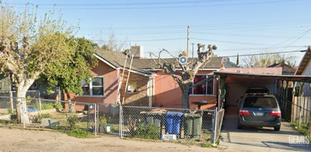 208 F St, Taft, CA 93268 - view of front of home with fence, driveway, a carport, and stucco siding