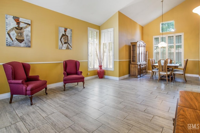 sitting room with plenty of natural light, baseboards, vaulted ceiling, and wood finish floors