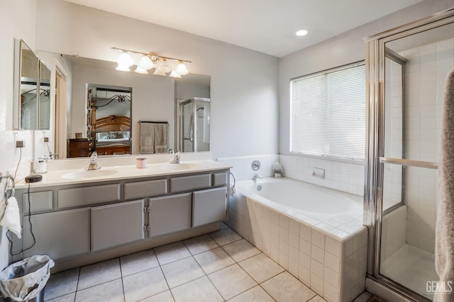 bathroom with double vanity, ensuite bathroom, a sink, a shower stall, and tile patterned flooring