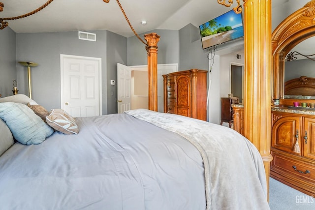 bedroom featuring vaulted ceiling, carpet flooring, decorative columns, and visible vents