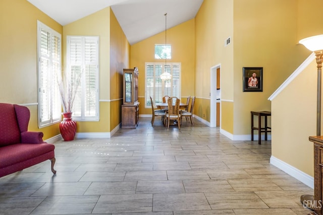 sitting room featuring high vaulted ceiling, wood tiled floor, visible vents, and baseboards