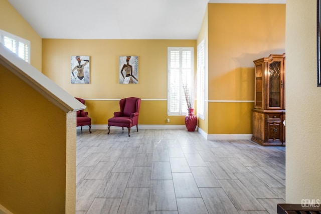 unfurnished room featuring vaulted ceiling, wood finish floors, and baseboards