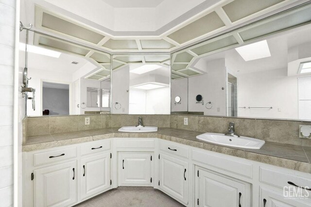 bathroom featuring a shower with door, vanity, and tasteful backsplash