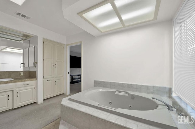 bathroom with a relaxing tiled tub and vanity