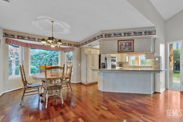 dining room featuring a healthy amount of sunlight, a notable chandelier, sink, and hardwood / wood-style floors