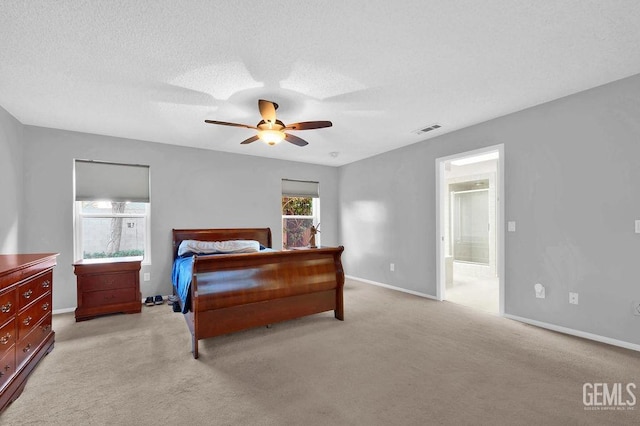 carpeted bedroom with ceiling fan, connected bathroom, and a textured ceiling