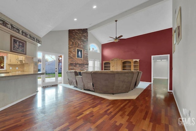 living room with dark wood-type flooring, ceiling fan, high vaulted ceiling, and beamed ceiling