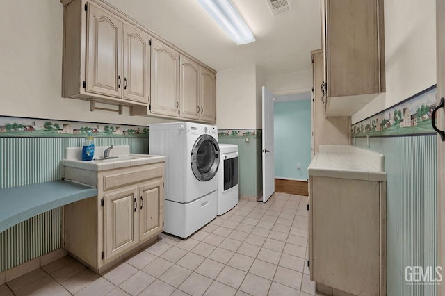 laundry room with sink, light tile patterned flooring, independent washer and dryer, and cabinets