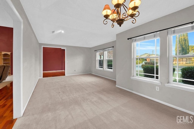 unfurnished living room featuring light carpet and an inviting chandelier