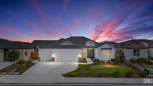 ranch-style house featuring concrete driveway, an attached garage, stone siding, and a yard