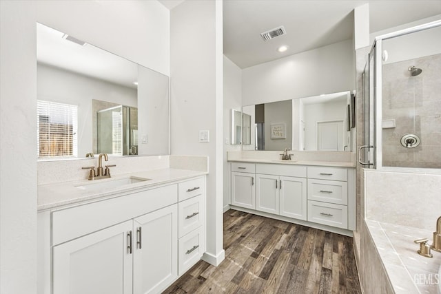 full bathroom with visible vents, a sink, and a shower stall