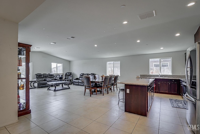 615 Welch Ave, Bakersfield, CA 93307 - kitchen featuring a sink, a kitchen breakfast bar, light tile patterned floors, lofted ceiling, and a kitchen island