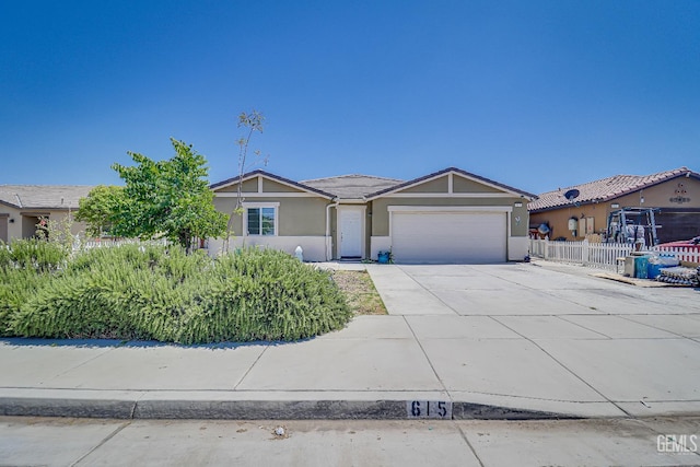 615 Welch Ave, Bakersfield, CA 93307 - view of front facade featuring an attached garage, driveway, and stucco siding