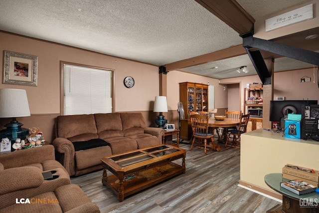 living room with hardwood / wood-style floors, beamed ceiling, and a textured ceiling